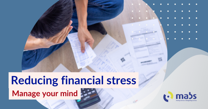 Blog post banner image contains an image of a guy sitting on the floor looking at his bills on the floor. Text on the banner reads "Reducing financial stress - Manage your mind"